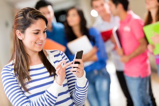 Female student texting from her cell phone at the university